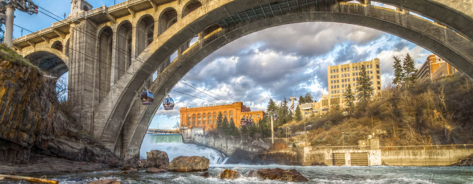 The Monroe bridge over the Spokane river and gondolas with the city skyline in the background.