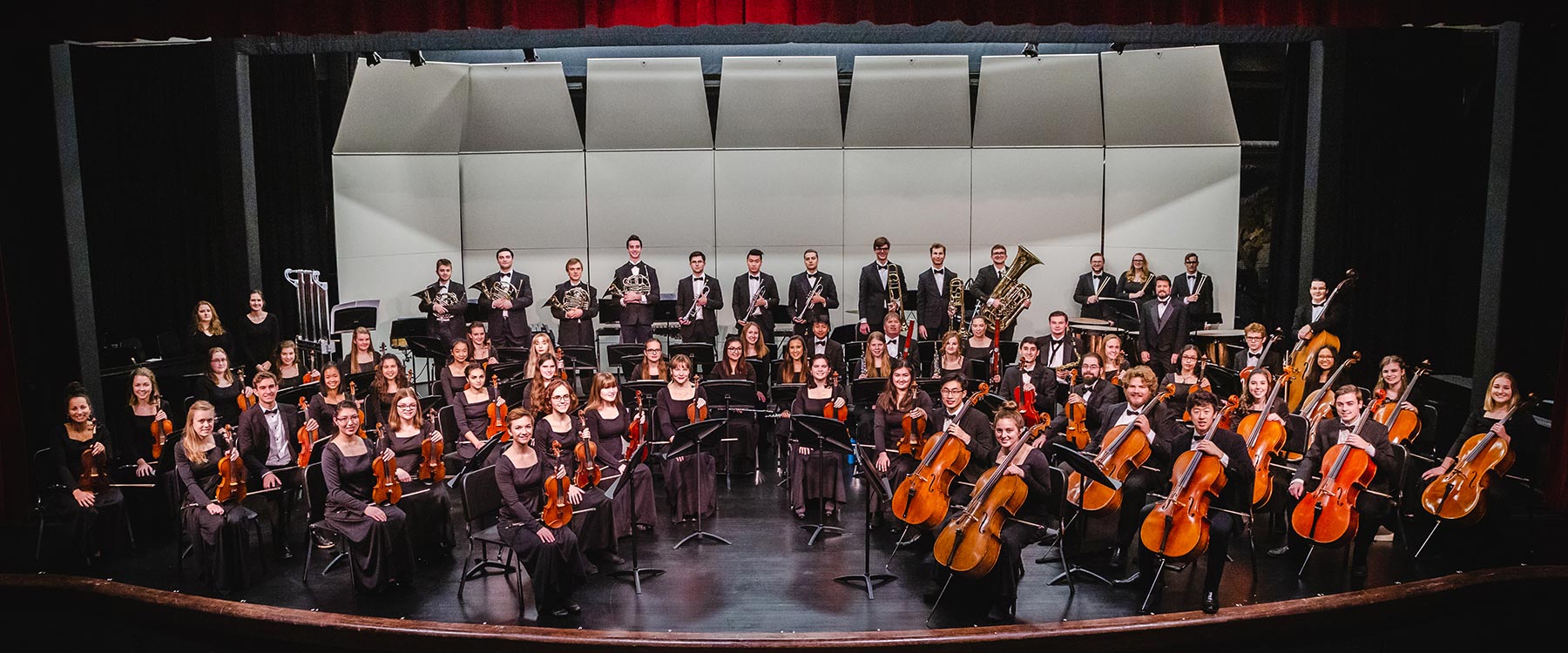 A professional photo of the 2018-19 Whitworth Symphony Orchestra on stage in concert attire.