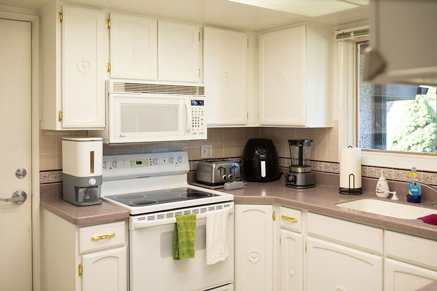 Bright kitchen with white cabinets, quality appliances and a window over the sink.