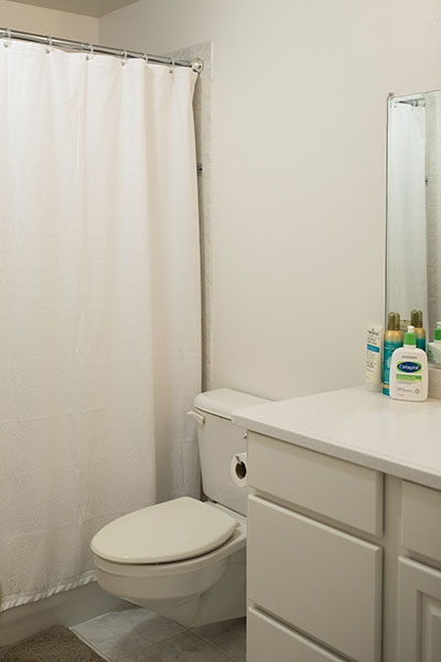 Clean, all-white bathroom with a shower, toilet and vanity.