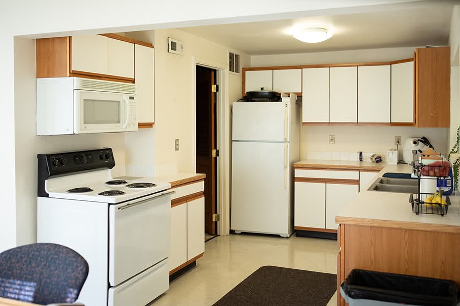 Large kitchen with full-size utilities and generous counter space. A dining set is seen in the next room.