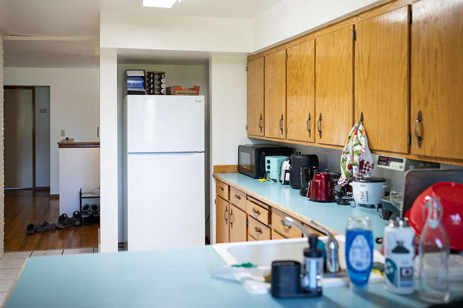 Large, open kitchen space with blue countertops and wooden cabinets.